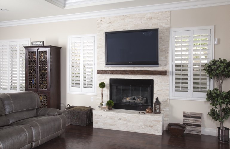 White plantation shutters in a Washington DC living room with dark hardwood floors.
